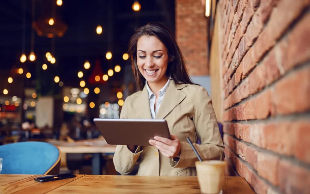 A café manager checking orders on a tablet