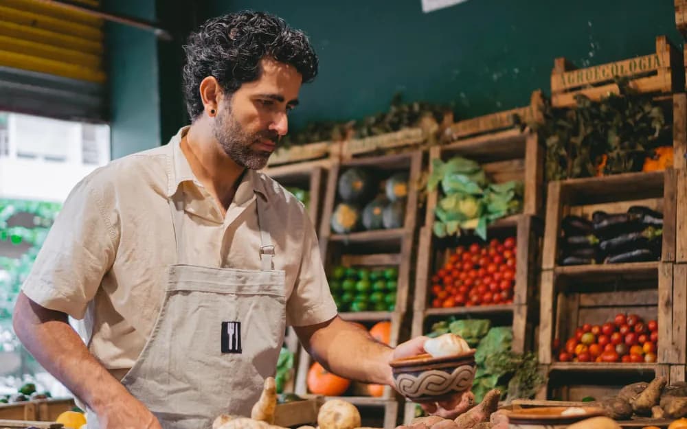 A grocer with fresh produce in his shop